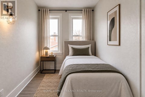 A bedroom with a large bed and a nightstand with a lamp.