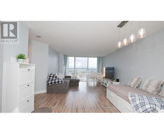 A well-lit, spacious living room with a grey sofa and a white couch.