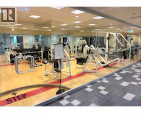 A gym with a variety of equipment including treadmills, weights and exercise machines.