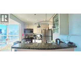 A modern kitchen with granite countertops and stainless steel appliances.