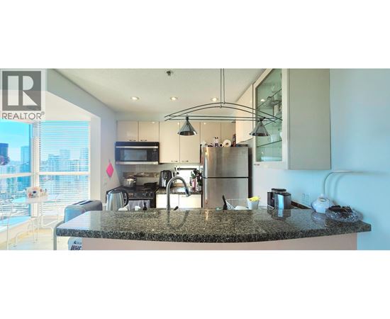 A modern kitchen with granite countertops and stainless steel appliances.