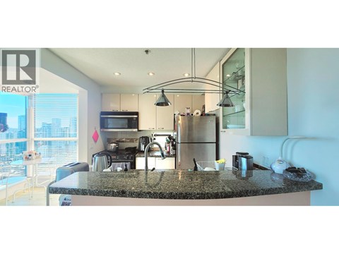 A modern kitchen with granite countertops and stainless steel appliances.
