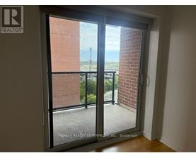 A room with a sliding glass door leading to a balcony.