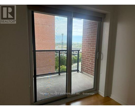 A room with a sliding glass door leading to a balcony.