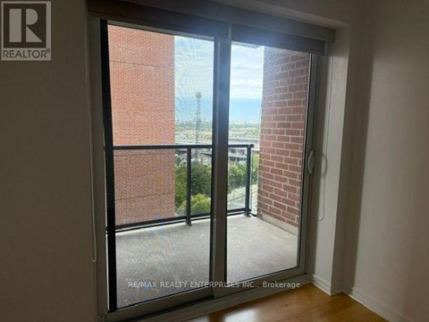 A room with a sliding glass door leading to a balcony.