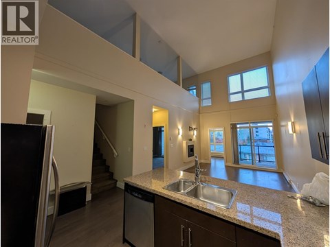 A kitchen with a sink and a refrigerator.
