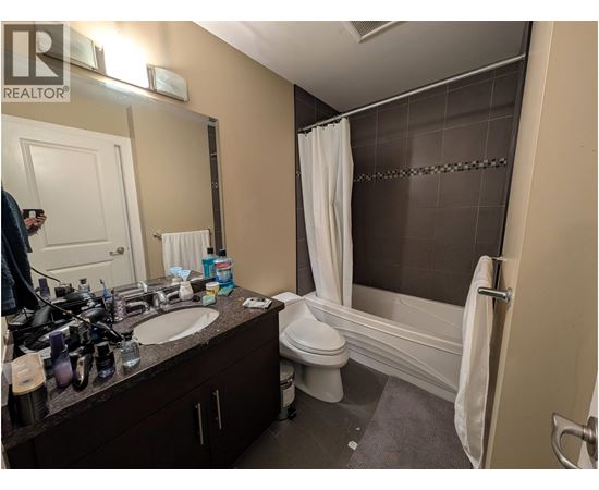 A bathroom with a white toilet, sink, and bathtub.
