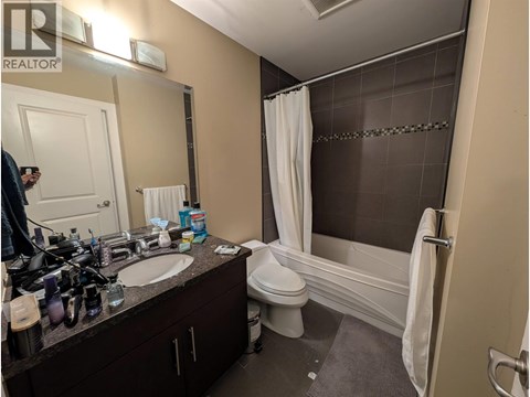 A bathroom with a white toilet, sink, and bathtub.