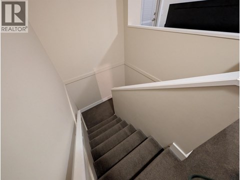 A staircase with a carpeted runner and white risers.