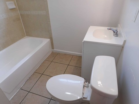 A white toilet sits next to a white sink in a bathroom.