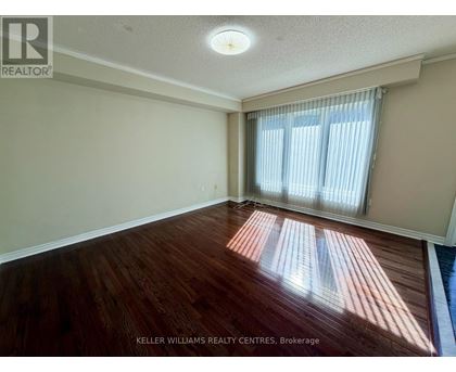 A room with wooden flooring and a window with curtains.