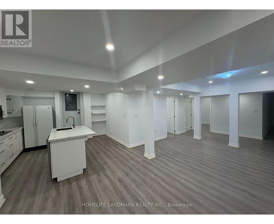 A spacious kitchen with white cabinets and a sink is shown in this image.