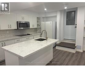 A kitchen with white cabinets and a marble countertop.
