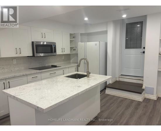 A kitchen with white cabinets and a marble countertop.