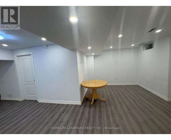 A room with a wooden table and grey carpet.