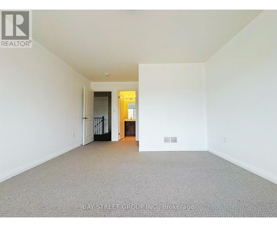 A large empty room with a doorway leading to another room.