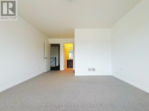 A large empty room with a doorway leading to another room.