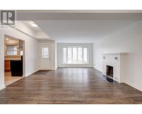 A spacious living room with a fireplace and hardwood floors.