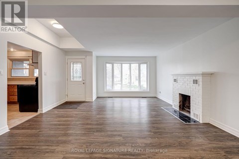 A spacious living room with a fireplace and hardwood floors.
