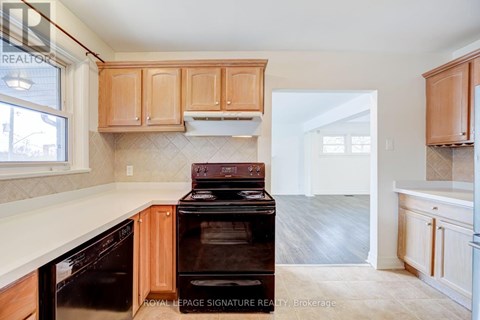 A kitchen with wooden cabinets and a black stove top oven.