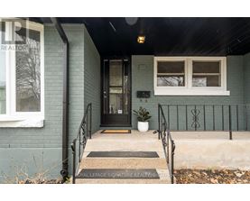 A house entrance with a black railing and a mat on the floor.