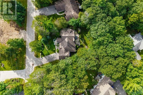 A bird's eye view of a residential area with houses surrounded by trees.