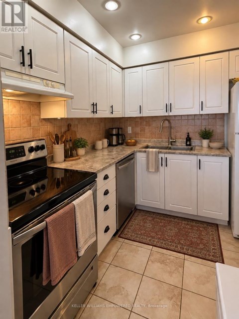 A kitchen with white cabinets and a black stove top.