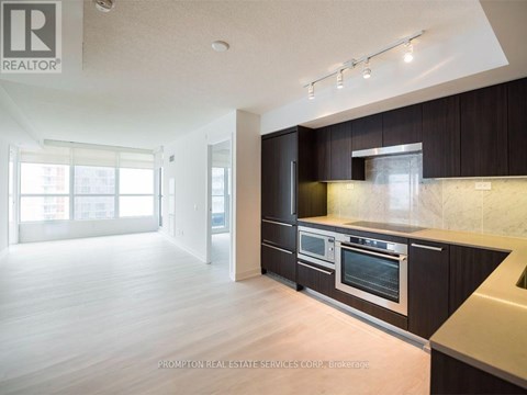 A kitchen with dark brown cabinets and stainless steel appliances.