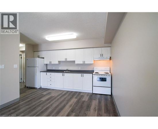 A kitchen with white cabinets and a stove top oven.