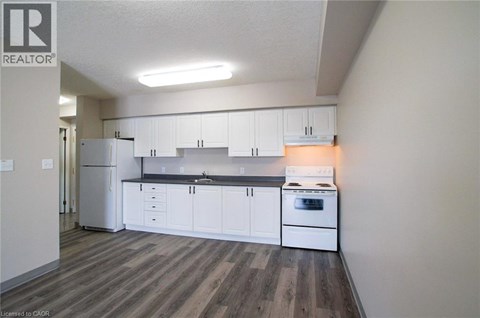 A kitchen with white cabinets and a stove top oven.