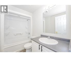 A white bathroom with a toilet, sink, and tub.