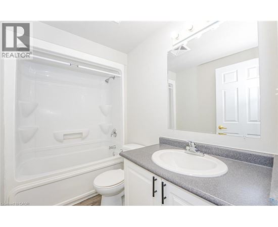 A white bathroom with a toilet, sink, and tub.
