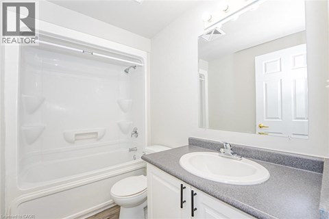 A white bathroom with a toilet, sink, and tub.