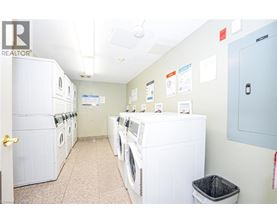 A laundry room with a row of washers and dryers.