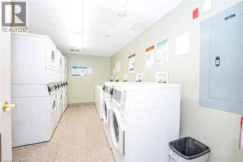A laundry room with a row of washers and dryers.
