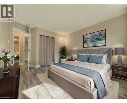 A bedroom with a large bed and a painting on the wall.