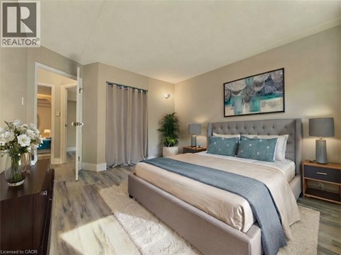 A bedroom with a large bed and a painting on the wall.