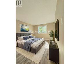 A bedroom with a bed, a nightstand, and a painting on the wall.