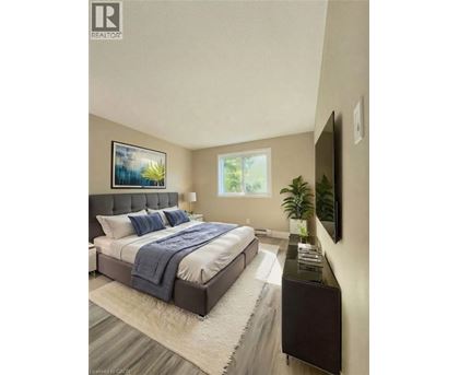 A bedroom with a bed, a nightstand, and a painting on the wall.