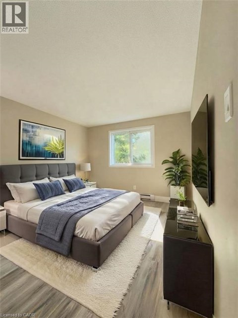 A bedroom with a bed, a nightstand, and a painting on the wall.
