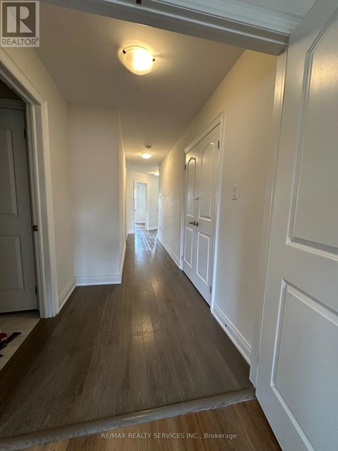 A hallway with wood floors and white walls.