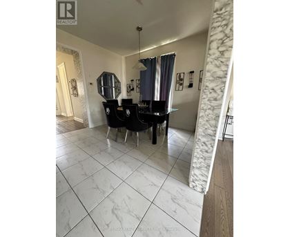A dining room with a table and chairs.