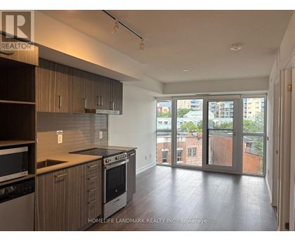 A kitchen with wooden cabinets and a black dishwasher.