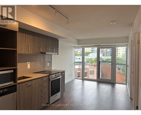 A kitchen with wooden cabinets and a black dishwasher.