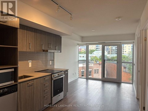 A kitchen with wooden cabinets and a black dishwasher.