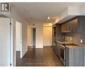 A kitchen with dark wood floors and modern appliances.