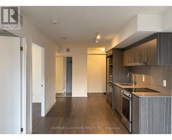 A kitchen with dark wood floors and modern appliances.