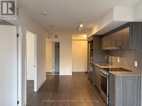A kitchen with dark wood floors and modern appliances.