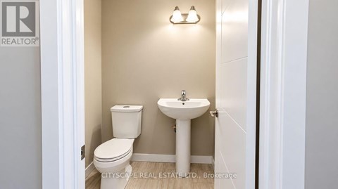 A white toilet and sink in a small bathroom.