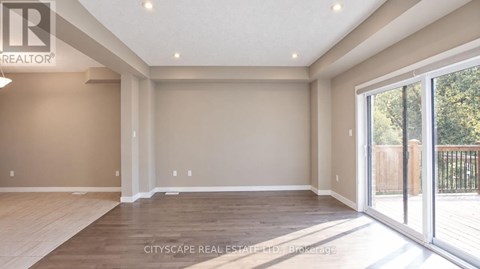 A spacious room with a sliding glass door leading to a balcony.